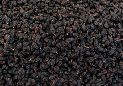 black sweet raisins dried sweet grapes background