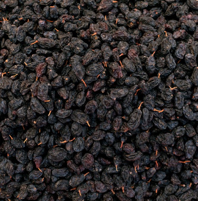 black sweet raisins dried sweet grapes background